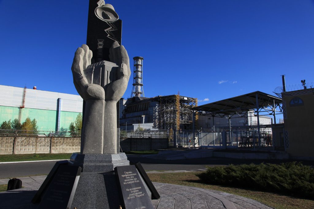 Spomenik žrtvama černobiljske nesreće i ikonička elektrana u pozadini. Foto: IAEA, Flickr